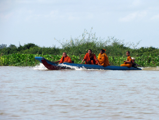 Mönche unterwegs auf den überschwemmten Feldern
